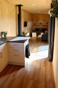 a kitchen with a stove and a living room at Luxury Container Cabin in Masterton
