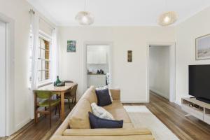ein Wohnzimmer mit einem Sofa und einem Tisch in der Unterkunft Katoomba Getaway 3 Bedroom Villa in Katoomba