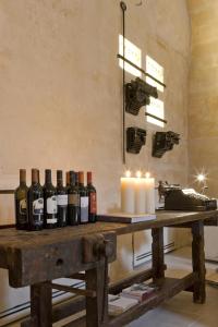 una mesa con botellas de vino y velas en Corte San Pietro, en Matera