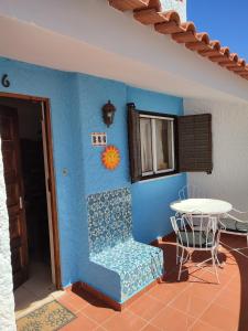 Habitación con pared azul, mesa y silla. en Recanto do Sol, en Hortas