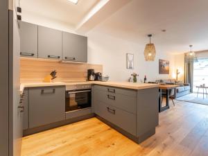 uma cozinha com armários cinzentos e piso em madeira em Ski Nature Apartment Lungau Top 13 em Mauterndorf