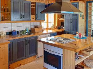 cocina con armarios azules y fogones en Holiday home Meløy, en Meløyskagen