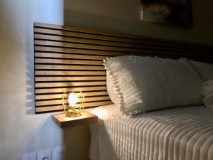 a bed with a lamp on a night stand next to it at The beach House- 1Room Apartment at Blue Bay resort in Sint Michiel