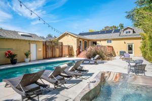 a backyard with a swimming pool with chairs and a house at with Heated Pool & Hot Tub! 3BR Napa Staycation Home home in Napa