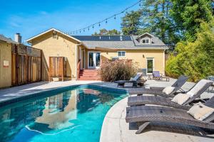 a swimming pool with chairs and a house at with Heated Pool & Hot Tub! 3BR Napa Staycation Home home in Napa