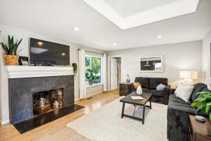 a living room with a fireplace with a tv above it at with Heated Pool & Hot Tub! 3BR Napa Staycation Home home in Napa