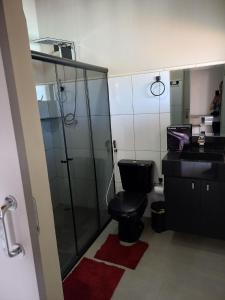 uma casa de banho com um WC e uma cabina de duche em vidro. em Chacara com piscina e muito lazer em Jarinu SP em Jarinu