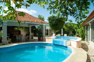 a swimming pool in a yard with a house at Casa Quinta Mar, Casa de campo en el Tule, Oaxaca. in Santa María del Tule