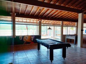 uma mesa de pingue-pongue no meio de uma sala em Chacara com piscina e muito lazer em Jarinu SP em Jarinu
