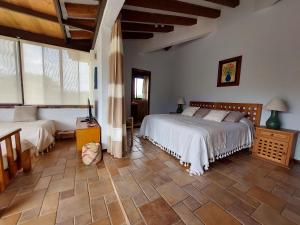 a bedroom with two beds and a large window at Casa Quinta Mar, Casa de campo en el Tule, Oaxaca. in Santa María del Tule