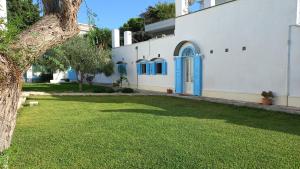 una casa blanca con una puerta azul y un patio en Villino Tronchetto Bianco, en Mola di Bari