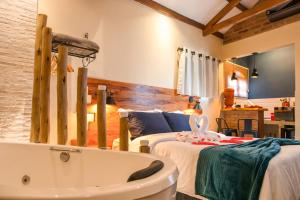 a room with two beds and a bath tub at Mantiqueira Flat in Santo Antônio do Pinhal