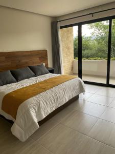 um quarto com uma cama grande e uma janela grande em Kali Secreto em Jalpan de Serra