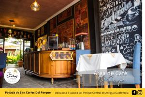 a bar in a restaurant with a counter and a table at Posada de San Carlos del Parque in Antigua Guatemala