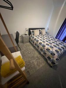 a bedroom with a bed and a chair in it at Cheerful Two Bedrooms Town house with free parking in Pembrokeshire