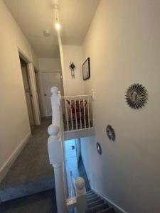 a hallway with a staircase with a mirror on the wall at Cheerful Two Bedrooms Town house with free parking in Pembrokeshire