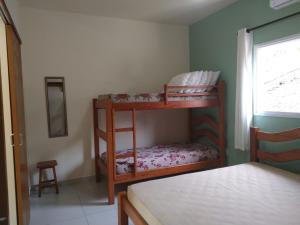 um quarto com 2 beliches num quarto em Canto Verde Aptos II em Caraguatatuba