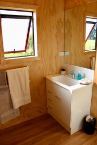 baño con lavabo blanco y ventana en Luxury Container Cabin en Masterton