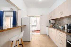 a kitchen with white cabinets and a white refrigerator at My Place @ Faro Skyline in Faro