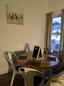 a table with a laptop on it in a room at Hillcrest Cottage, comfy flat, trendy Uplands area in Swansea