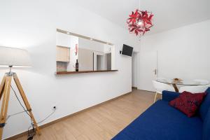 a living room with a blue couch and a mirror at My Place @ Faro Skyline in Faro