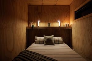 a bedroom with a bed with two pillows and candles at Luxury Container Cabin in Masterton
