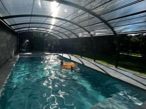 een groot zwembad met een luifel erboven bij Farm with indoor pool and bubble bath in Houyet