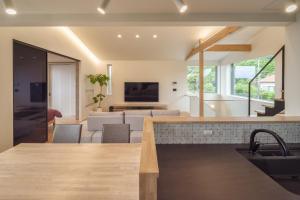 a kitchen and living room with a couch and a tv at KeiU-Yakushima Luxury Guest House in Yakushima