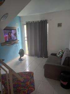 マンガラチバにあるLinda casa em Condomínio no Sahyのリビングルーム(ソファ、薄型テレビ付)