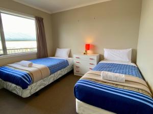 two beds in a room with a window at Rocking it On Rhoboro in Twizel