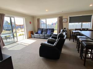 a living room with a couch and a table and chairs at Rocking it On Rhoboro in Twizel