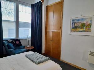 a bedroom with a bed and a chair and a window at Turret House in Featherston