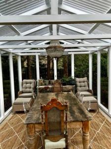 einen Holztisch und Stühle auf einer Terrasse mit einer Decke in der Unterkunft Sunnyside Luxurious 4BR Art Villa, Fireplace, Village 2mins in Wentworth Falls