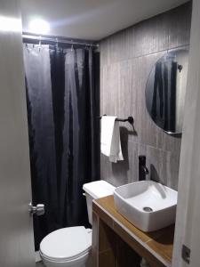 a bathroom with a white toilet and a sink at APARTAMENTOS AMBASSADOR in Tijuana