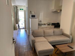 a living room with a couch and a kitchen at ホテルトーマス牧志 in Naha