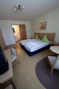 リップシュタットにあるGasthof Brinkmeierのベッド、テーブル、椅子が備わるホテルルームです。