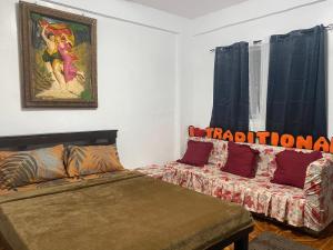 une chambre avec un lit, un canapé et un tableau dans l'établissement Traditional Filipino Home near 100 Islands Wharf, à Alaminos