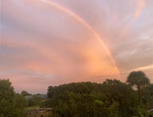 a rainbow in the sky over some trees at Traditional Filipino Home near 100 Islands Wharf in Alaminos