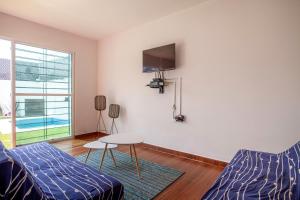 a living room with a couch and a table and a tv at Casa con alberca privada y jardin in Cuautla Morelos
