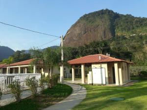 una casa con una montagna sullo sfondo di Linda casa em Condomínio no Sahy a Mangaratiba