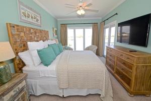 a bedroom with a bed with a television and a dresser at Dolphin Harbor 3C in Orange Beach