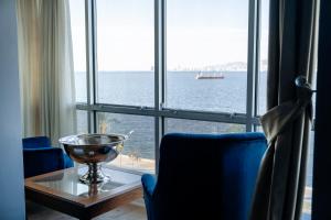 een kamer met een tafel en uitzicht op de oceaan bij Mira Hotel Boutique in Izmir