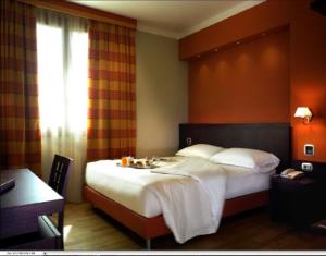 スカルペリーアにあるホテル デイ ヴィカーリのベッドと窓が備わるホテルルーム