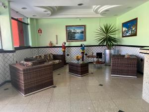 un vestíbulo con sofás y una planta en una habitación en Pousada Ferreira, en Aracaju