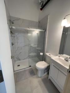 a bathroom with a shower and a toilet and a sink at Sandwich Boutique Hotel in Windsor