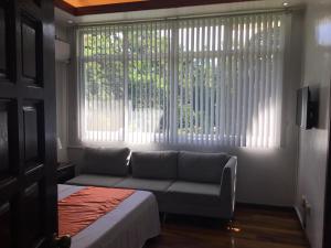 un soggiorno con divano di fronte a una finestra di Camiguin Lanzones Resort a Mambajao