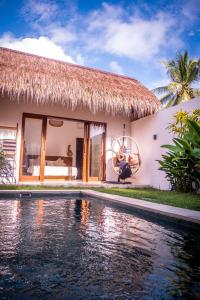 eine Villa mit einem Pool vor einem Haus in der Unterkunft Palm Merah Villas - Private pool in Selong Belanak
