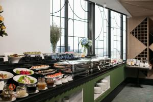 a buffet line with dishes of food on display at Aurora Premium - A Lifestyle Hotel in Hanoi