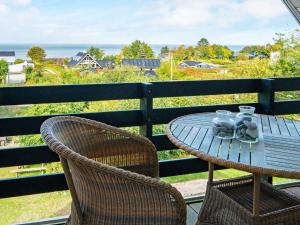 Nøragerにある10 person holiday home in Alling broのテーブルと椅子、海の景色を望むバルコニー