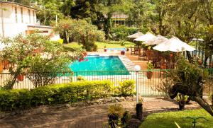 a pool with tables and umbrellas and a restaurant at Bird Of Paradise Hotel in Goroka